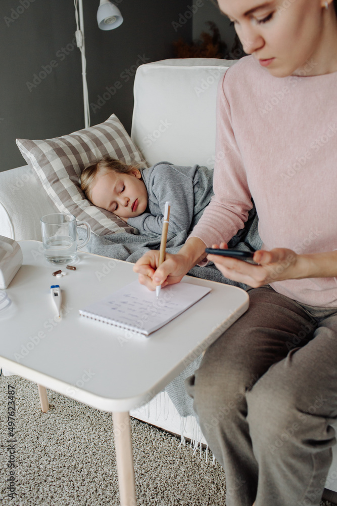 Woman taking notes in notepad for treating child