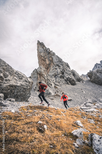 Active couple running in front of pointy mountain peak. photo