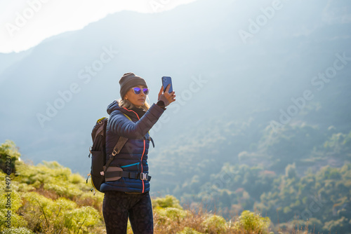 Female hiker taking photos in nature photo