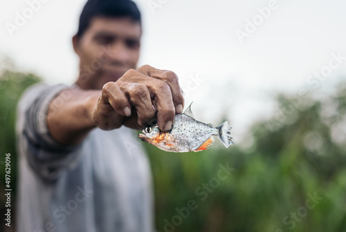 Fisherman showing a piranha photo
