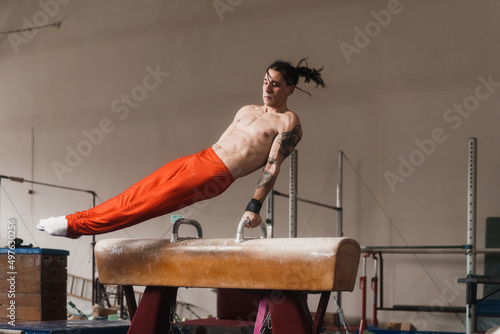 Male Gymnast Working Out His Routine On A Pommel Horse photo