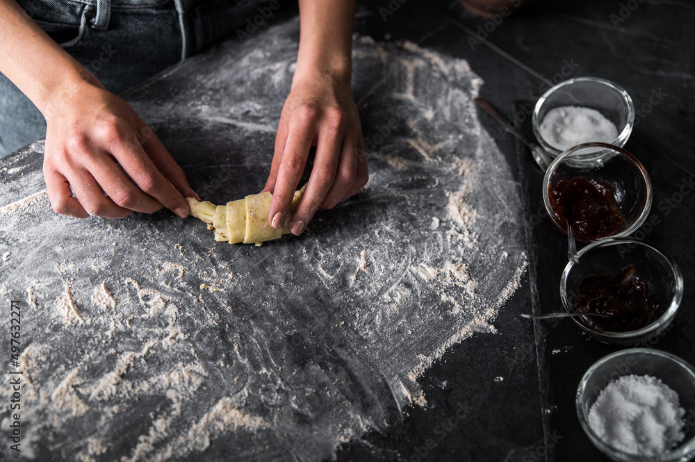 Unrecognizable woman preparing croissant on table Unrecognizable woman preparing croissant on table