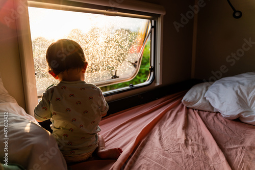 Baby  in the motorhome window looking outside photo