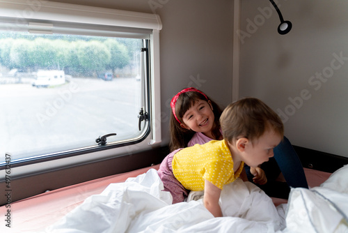Little girls playing on RV bed photo
