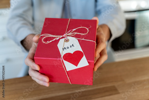 Man showing present for his mother at camera photo