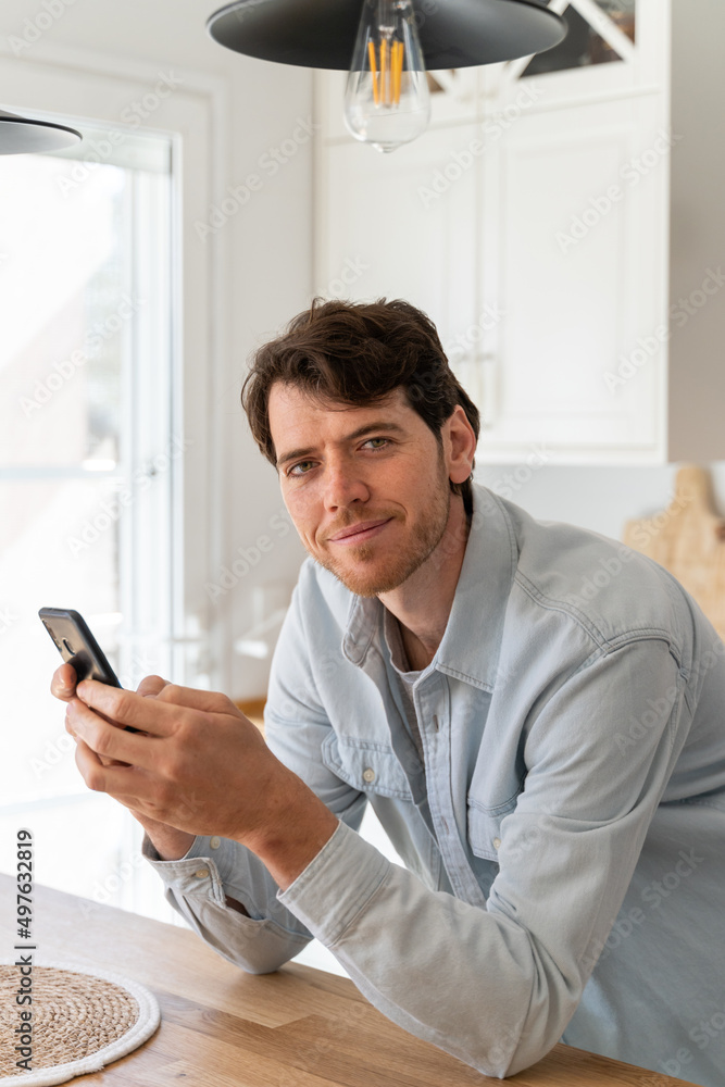 Portrait of happy confident man with phone at home Portrait of happy confident man with phone at home