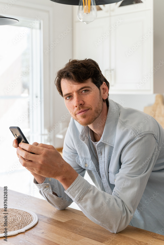 Portrait of happy confident man with phone at home Portrait of happy confident man with phone at home