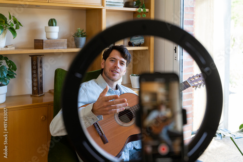 Close-up of Man shooting a video playing guitar photo