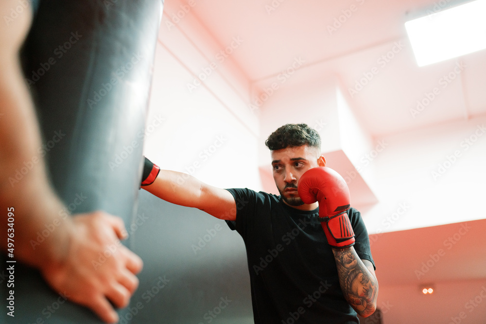 Male boxer exercising with trainer in gym Male boxer exercising with trainer in gym