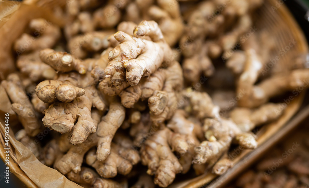 Close up of fresh aroma ginger roots in the wicker basket outdoor on market counter