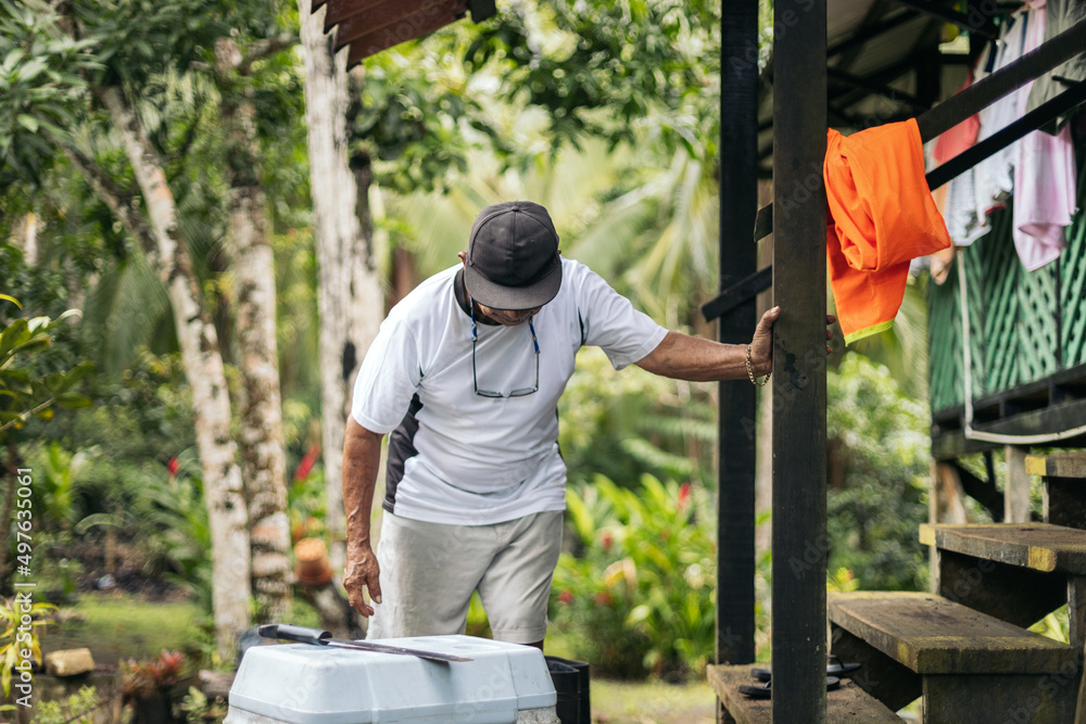 Old man with a cap in the yard of his house Old man with a cap in the yard of his house