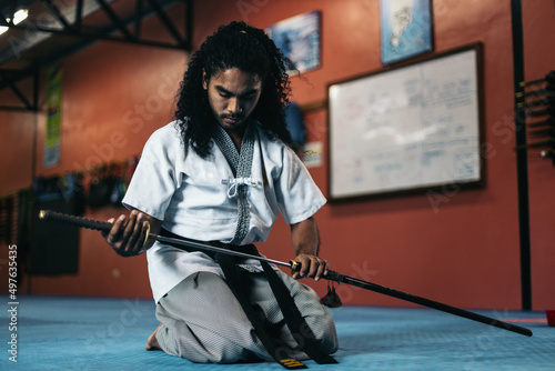 Martial arts fighter sheathing his katana photo