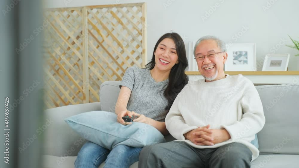 Asian senior father and daughter watch funny movie together at home. Asian senior father and daughter watch funny movie together at home.