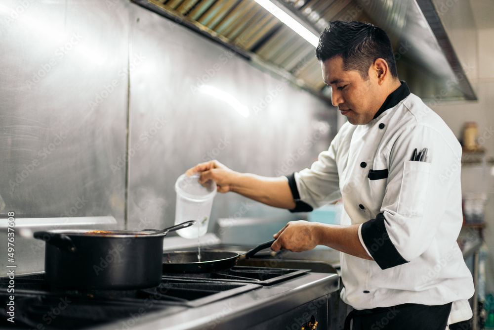 Latin cook working in a restaurant kitchen Latin cook working in a restaurant kitchen