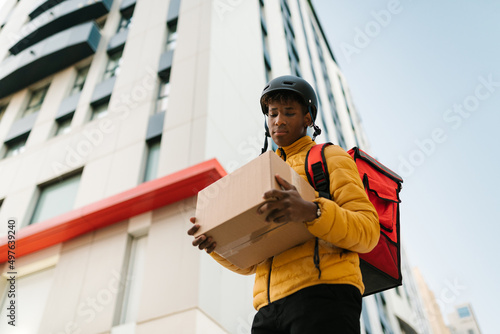 Delivery man reading address on box