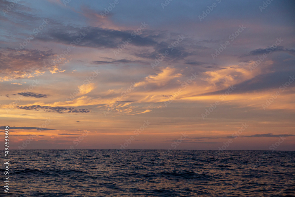 sunset with pastel colored clouds in the ocean sunset with pastel colored clouds in the ocean