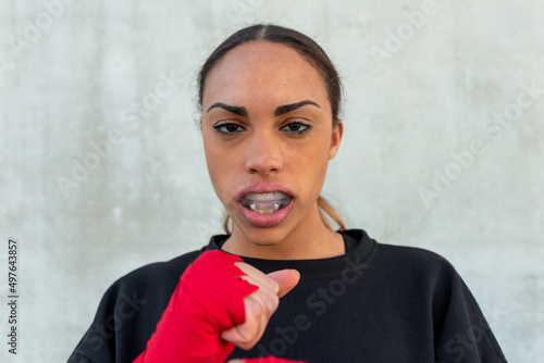 Confident female boxer in mouth guard during training photo
