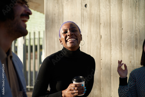Cheerful woman drinking coffee on street
