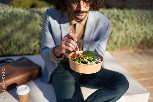 Male freelancer having lunch in park