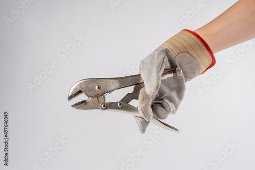 Hand hloding locking pliers isolated on white background, And mechanic gloves. photo