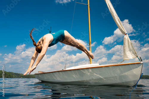 Diving off Small Sailboat Anchored on Northern Cottage Lake photo