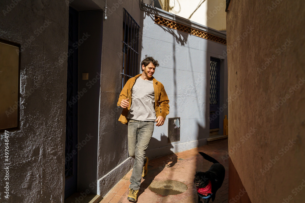 Happy confident man running with dog in the city Happy confident man running with dog in the city