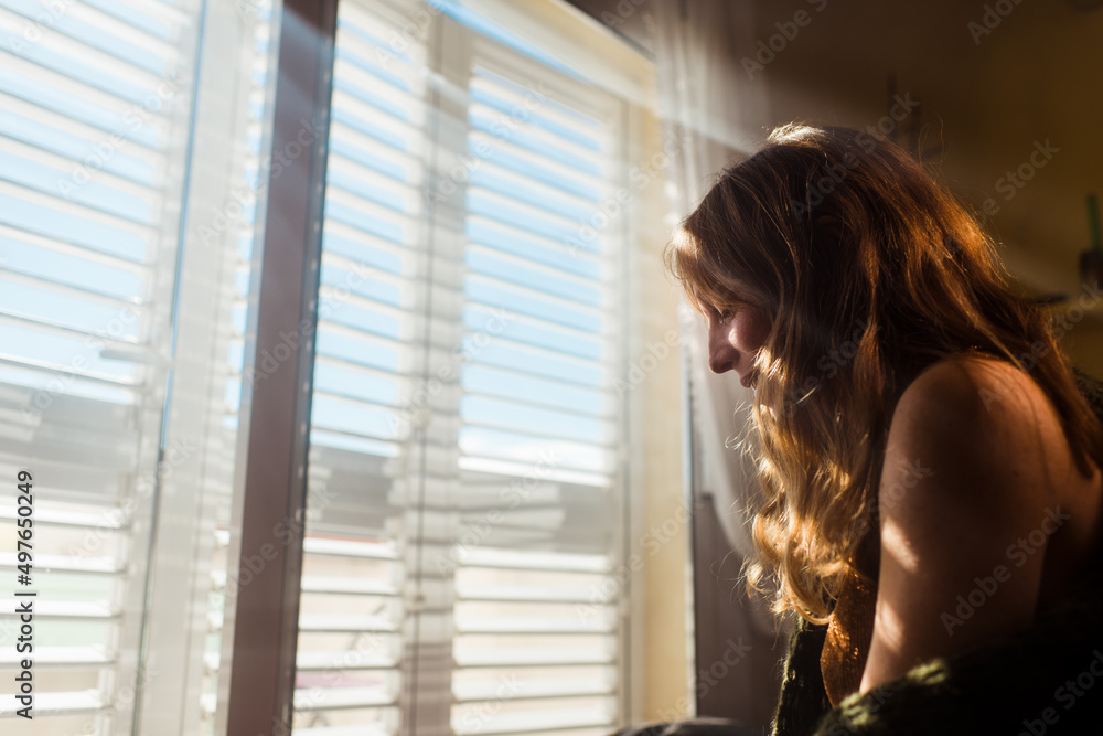 Smiling woman near sunny window Smiling woman near sunny window
