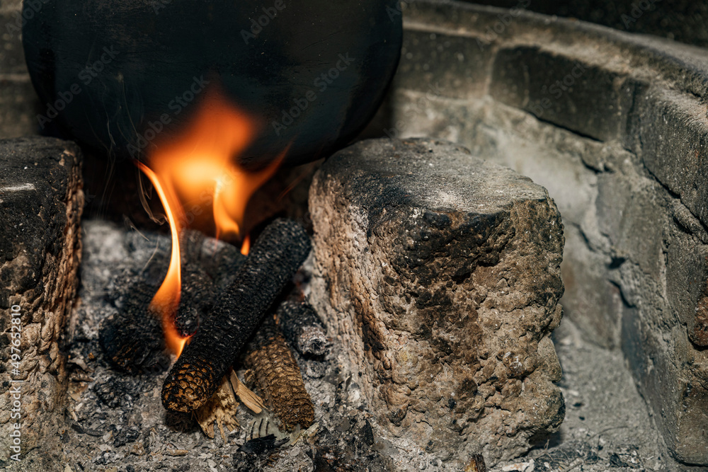 black clay pot over the fire in a traditional kitchen black clay pot over the fire in a traditional kitchen