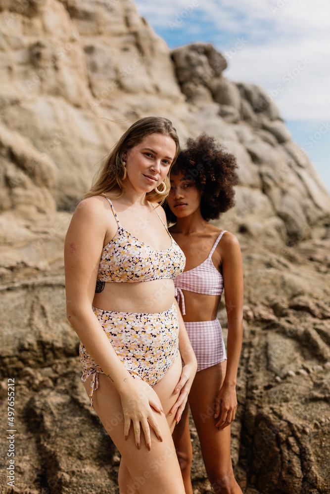 two girls posing in front of the seashore two girls posing in front of the seashore