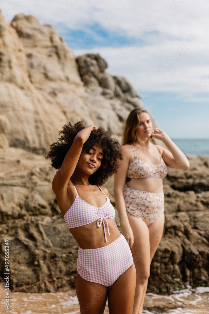 two women posing in front of the sea two women posing in front of the sea