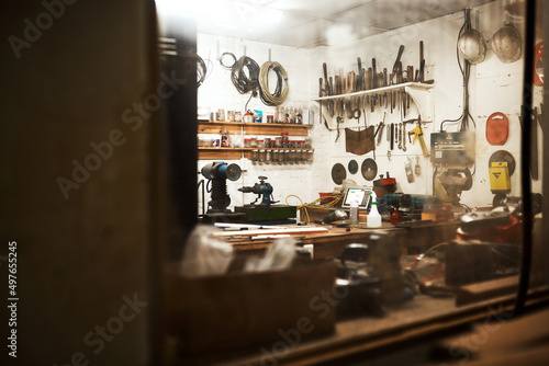 This is my workshop. Shot of a workshop filled with different types of tools inside someones home at night.