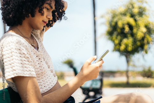 Young trans woman checking her phone photo