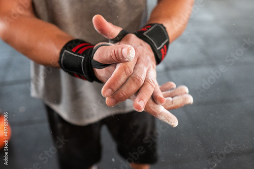 Crop athlete clasping powdered hands photo