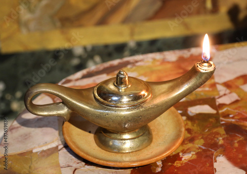 Ancient vintage golden oil lamp with fire