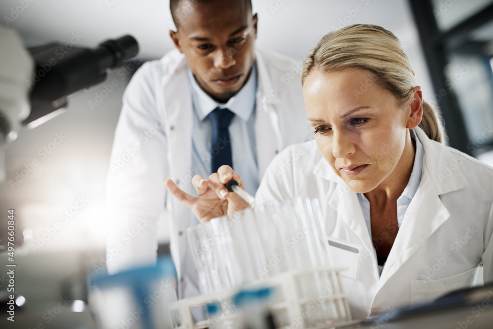 What they do saves lives. Cropped shot of two scientists testing a sample while doing research in their lab. What they do saves lives. Cropped shot of two scientists testing a sample while doing research in their lab.