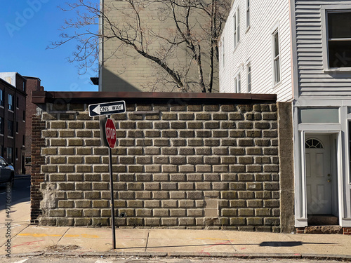 Urban sidewalk neighborhood Street brick Wall with one way sign
