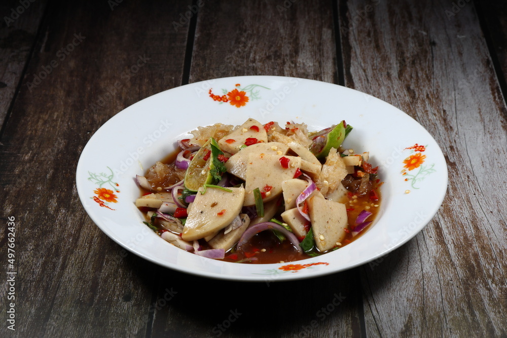 Traditional spicy salad of pork sausage and mixed vegetable serving on the plate. Famous street food menu in Asia.