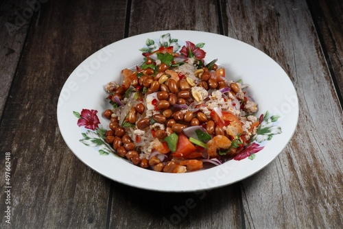 Traditional spicy fresh vermicelli or glass noodle with mince pork and roasted peanut serving on the plate. Famous street food menu in Thailand.