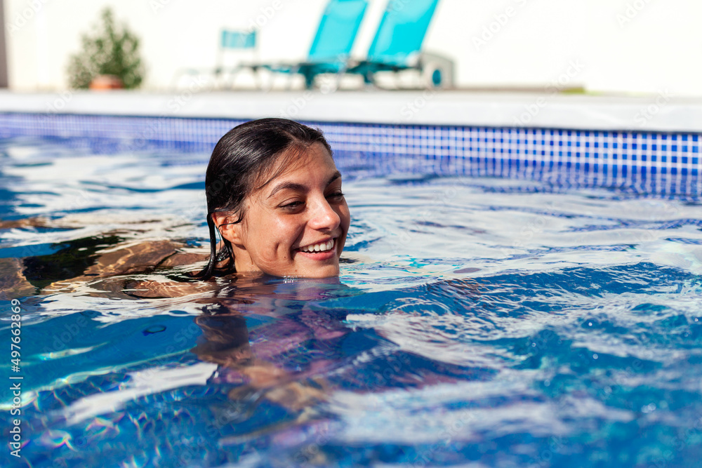 © Ezequiel Giménez/Stocksy - Cheerful woman swimming in summer pool © Ezequiel Giménez/Stocksy - Cheerful woman swimming in summer pool