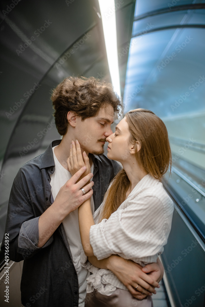 The guy gently hugs his girlfriend near the travolator The guy gently hugs his girlfriend near the travolator