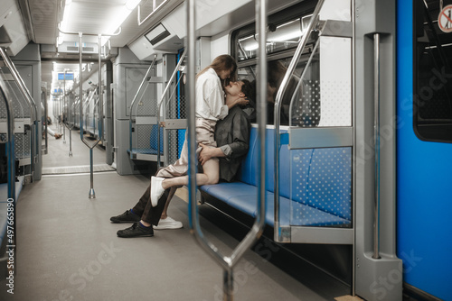 A couple in love passionately embraces in an empty subway car photo
