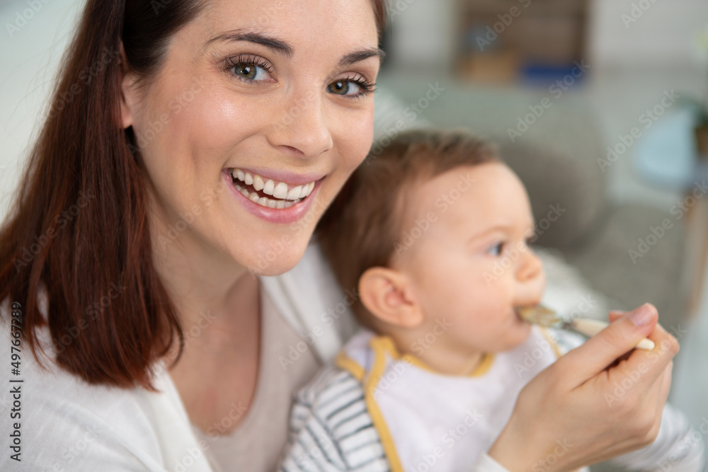 happy mum spoon feeding child son indoors happy mum spoon feeding child son indoors