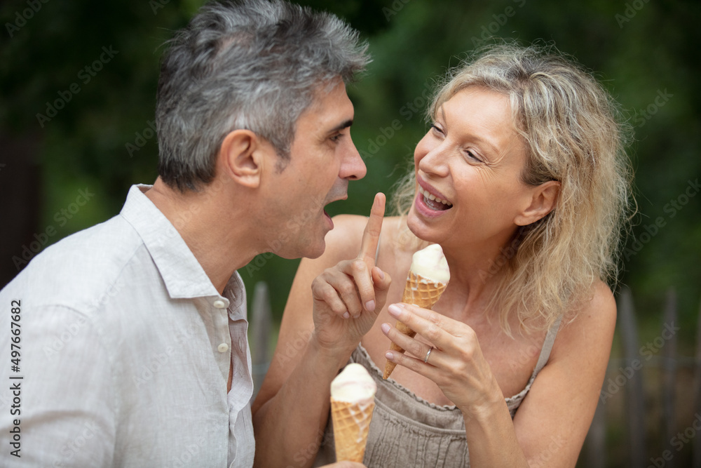 middle aged couple enjoying ice cream together middle aged couple enjoying ice cream together
