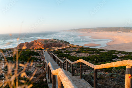 Sunset beach landscape with wooden path to the sea