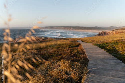 Sunset beach landscape with wooden path to the sea photo