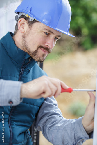 a male builder is using screwdriver