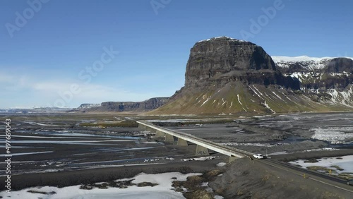 Vehicles Crossing At One Lane Bridge Spanning Nupsvotn River With Lomagnupur Mountain View. - aerial photo