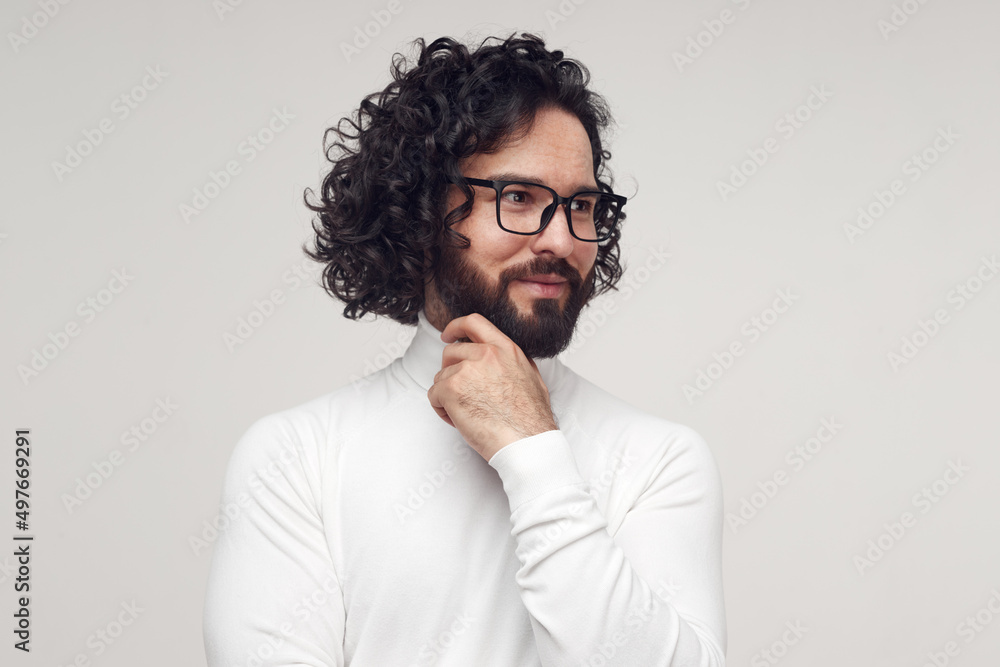 Obraz premium Smart male in glasses touching chin in studio