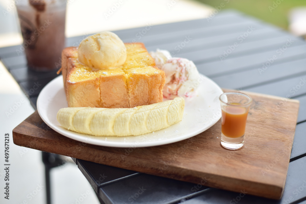 Honey toast with banana on white plate.