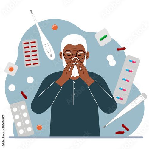 A man covers his nose with his hands with a handkerchief. The concept of a cold person, seasonal allergies. Lots of medicines and thermometers.